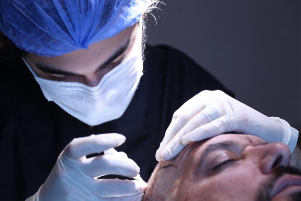 Chirurgien réalisant une greffe de cheveux DHI à la Medhair Clinic en Turquie.
