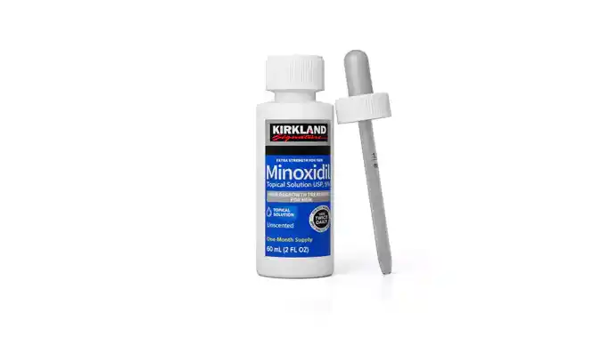 Flacon de Kirkland Signature Minoxidil 5 % en solution topique avec son compte-gouttes, utilisé comme sérum pour stimuler la pousse de la barbe